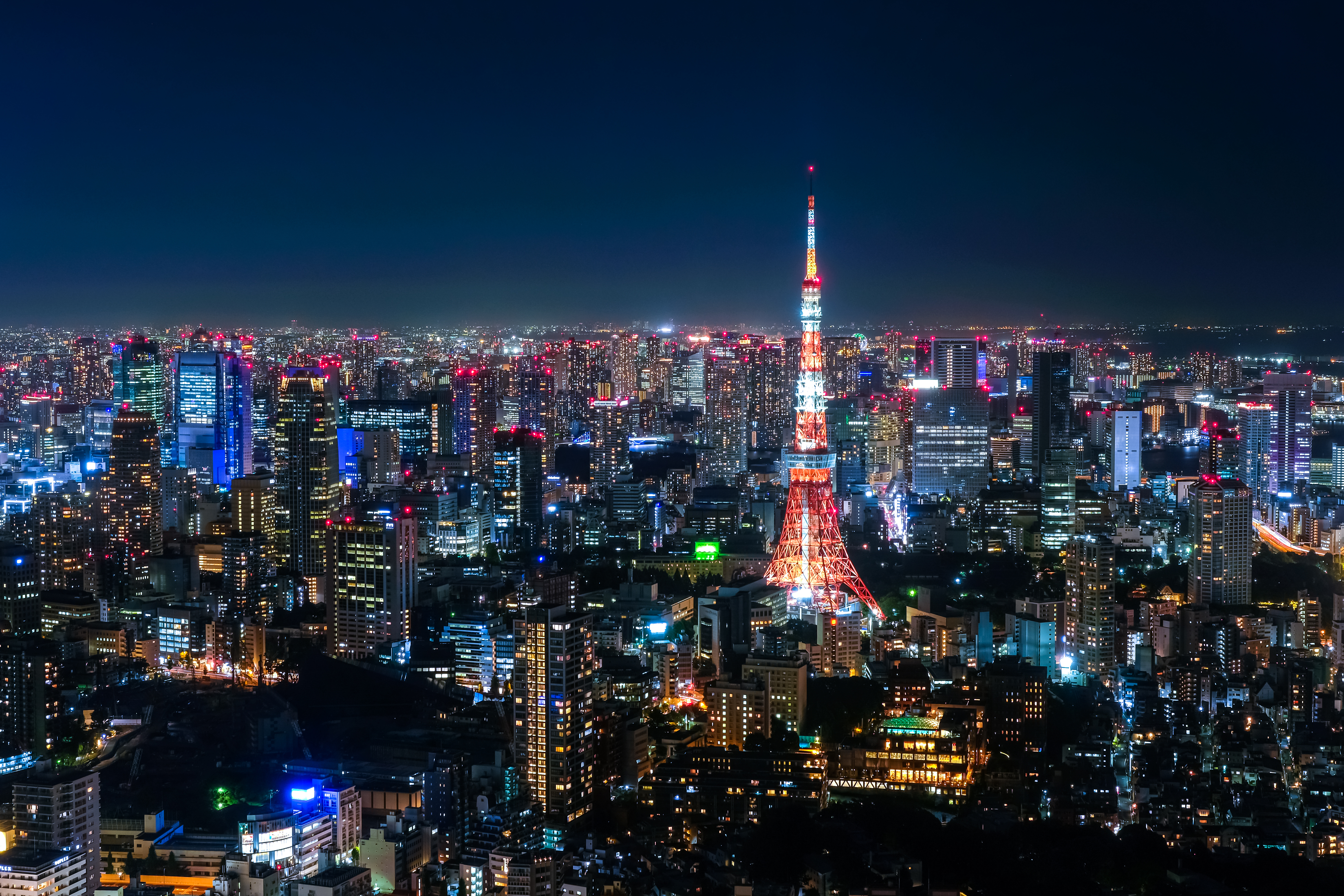 Roppongi night skyline with neon-lit streets and Tokyo Tower in the distance