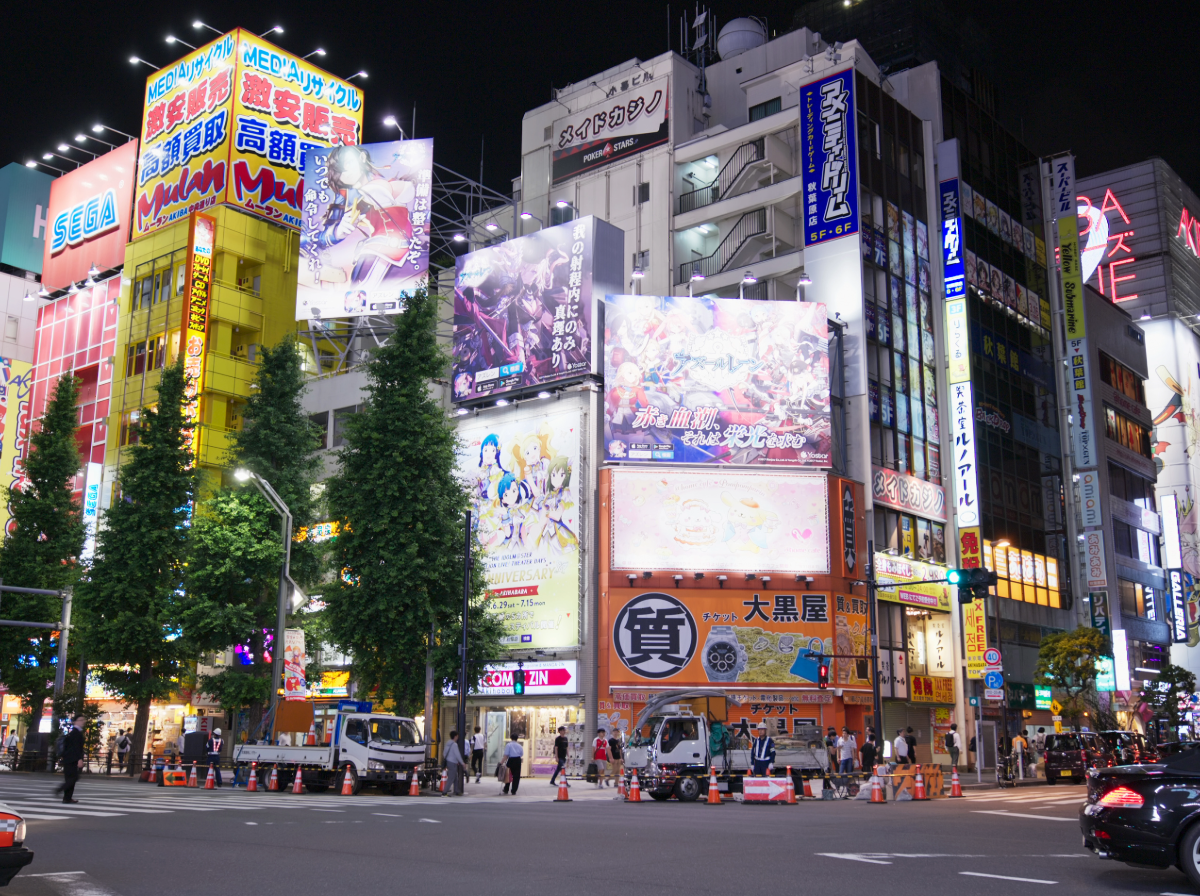Akihabara district in Tokyo at night, neon signs and anime culture storefronts, the birthplace of Japan's cosplay scene