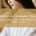 Close-up editorial photograph of a young Japanese woman's lower face and shoulders with natural makeup, soft features, and clean white blouse styling
