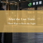 Adult solo traveler outside a Tokyo station after the last train, considering the hours before morning